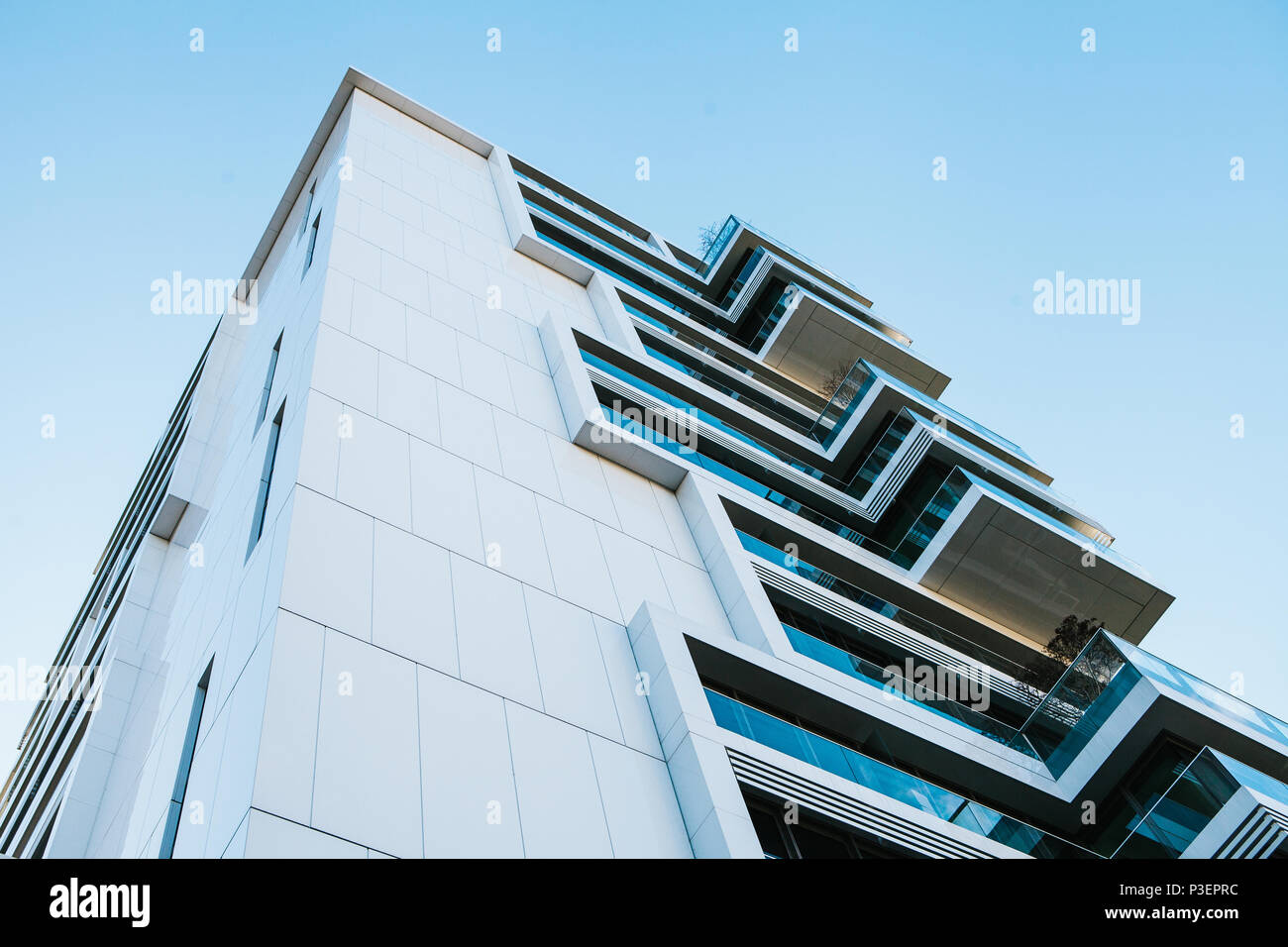 L'angolo dell'edificio con molte finestre contro il cielo blu Foto Stock