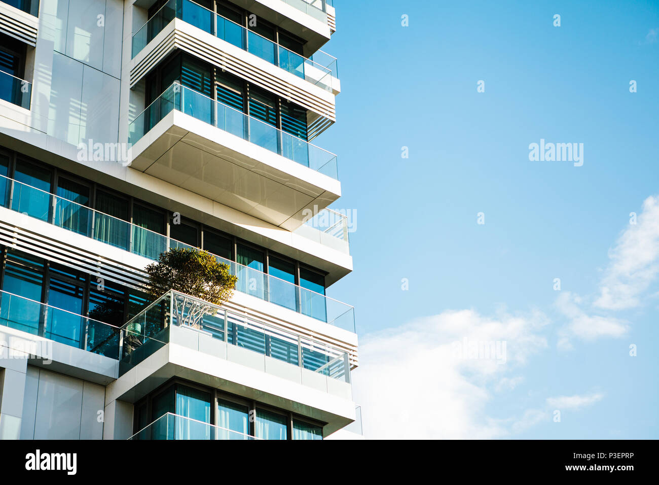 L'angolo dell'edificio con molte finestre contro il cielo blu Foto Stock