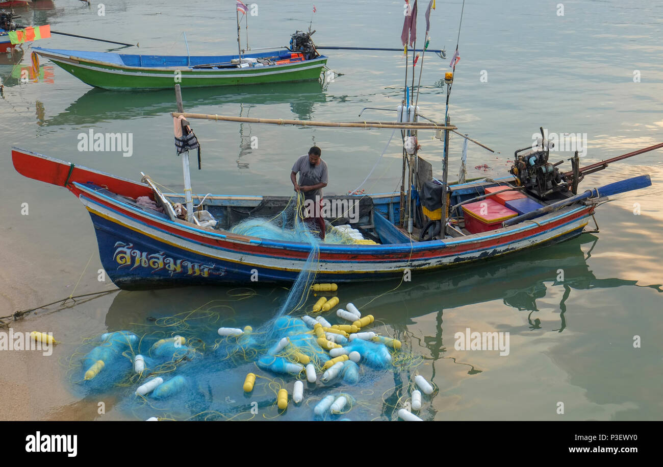 Thailandia Koh Samui, East Coast Baan Hua Thanon. Un musulmano villaggio di pescatori. pescatore si ripiega il suo fishnets nella sua barca Foto Stock