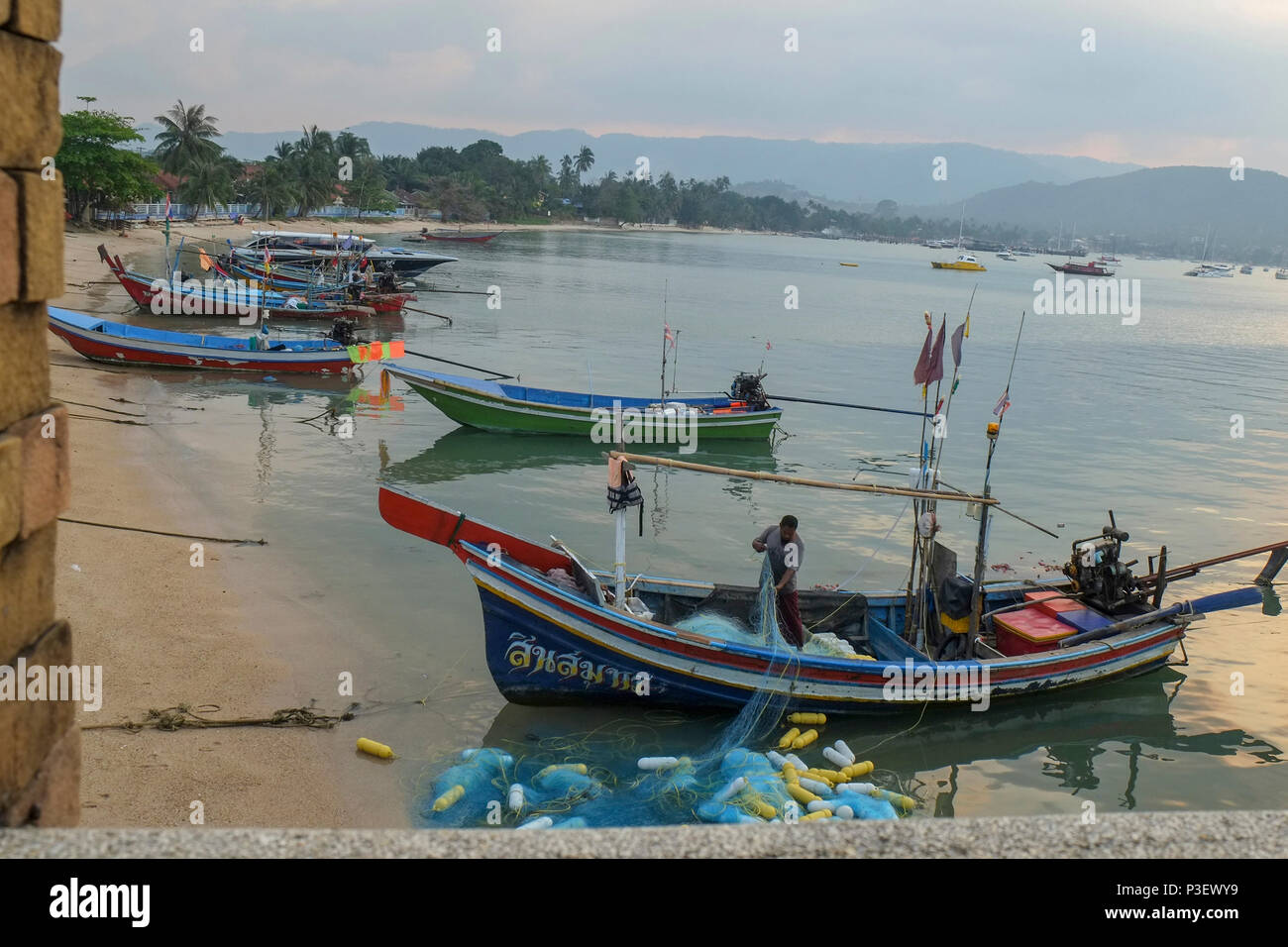 Thailandia Koh Samui, East Coast Baan Hua Thanon. Un musulmano villaggio di pescatori. pescatore si ripiega il suo fishnets nella sua barca Foto Stock