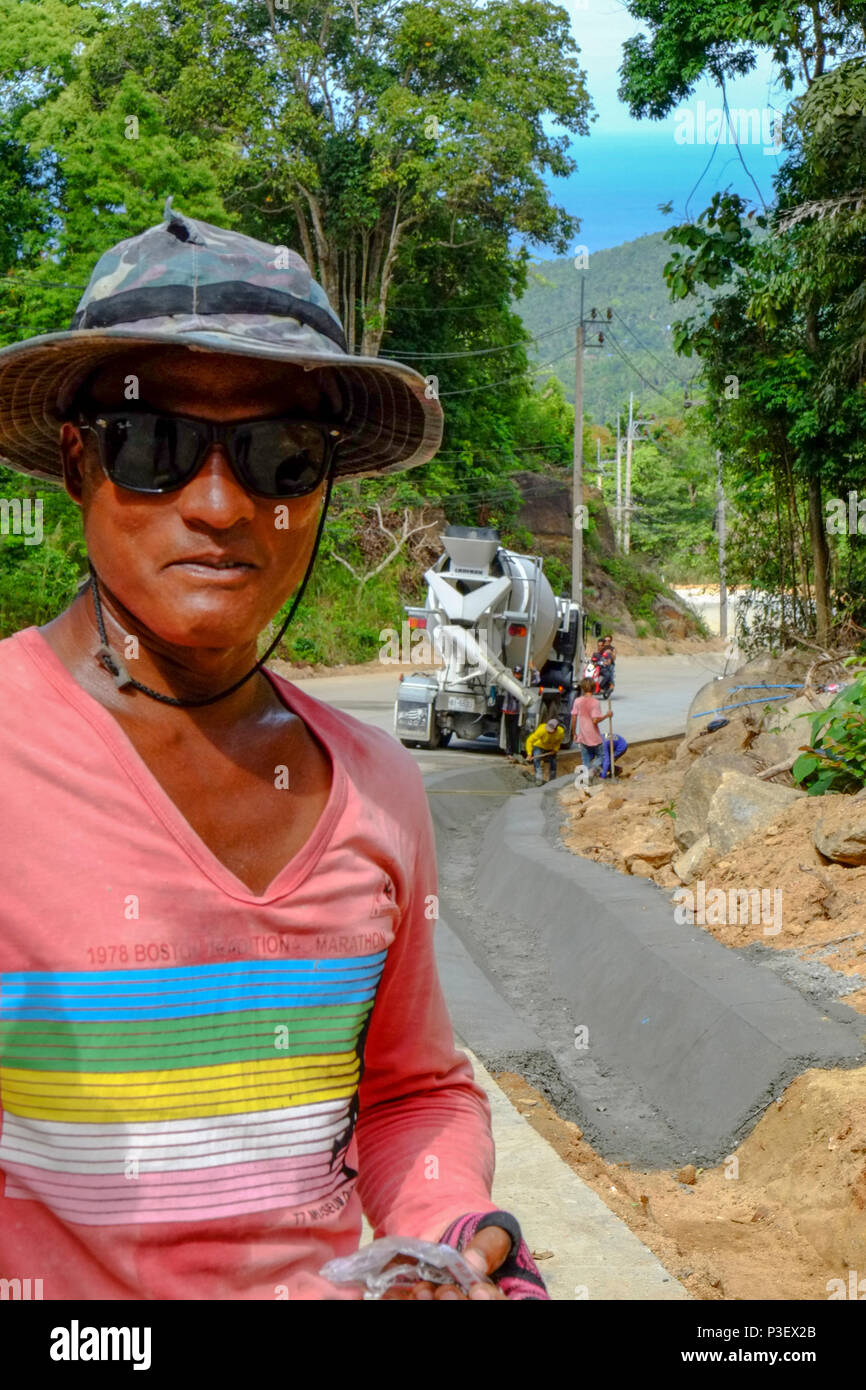 Lavoratori edili provenienti dal Myanmar sono la costruzione di nuove strade attraverso la giungla che copre le montagne dell'isola thailandese di Koh Phangan, Thailandia Foto Stock