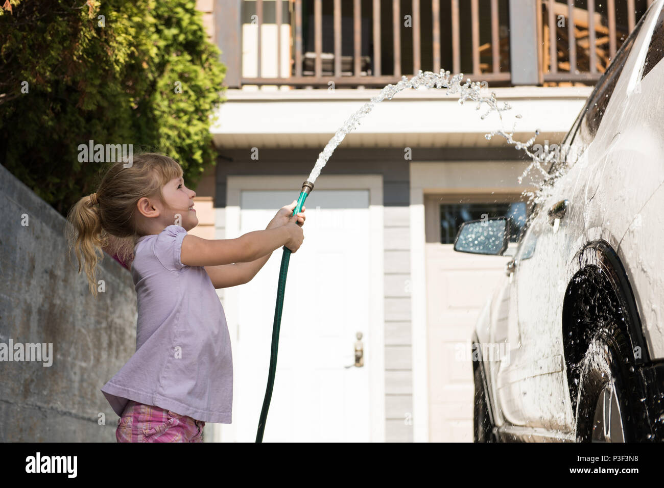 Ragazza un lavaggio auto presso un garage esterno Foto Stock