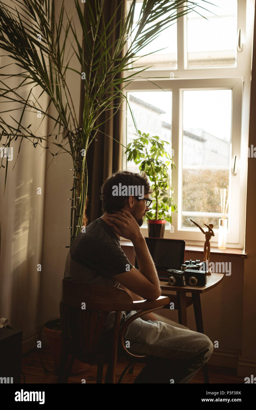 Uomo seduto con fotocamera vintage a tavola Foto Stock