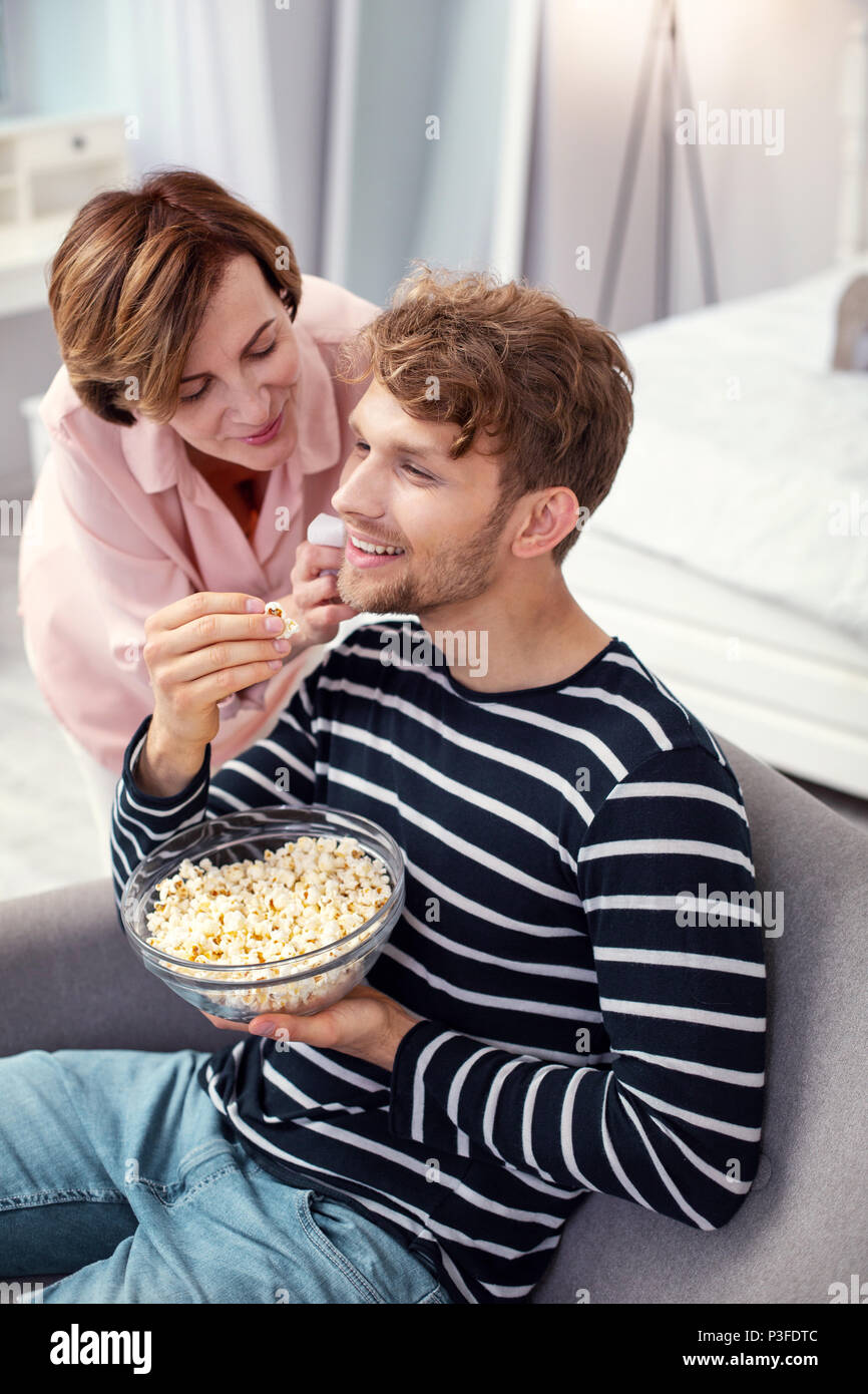 Gioioso uomo positivo mangiare popcorn Foto Stock Gioioso uomo positivo mangiare popcorn Foto Stock