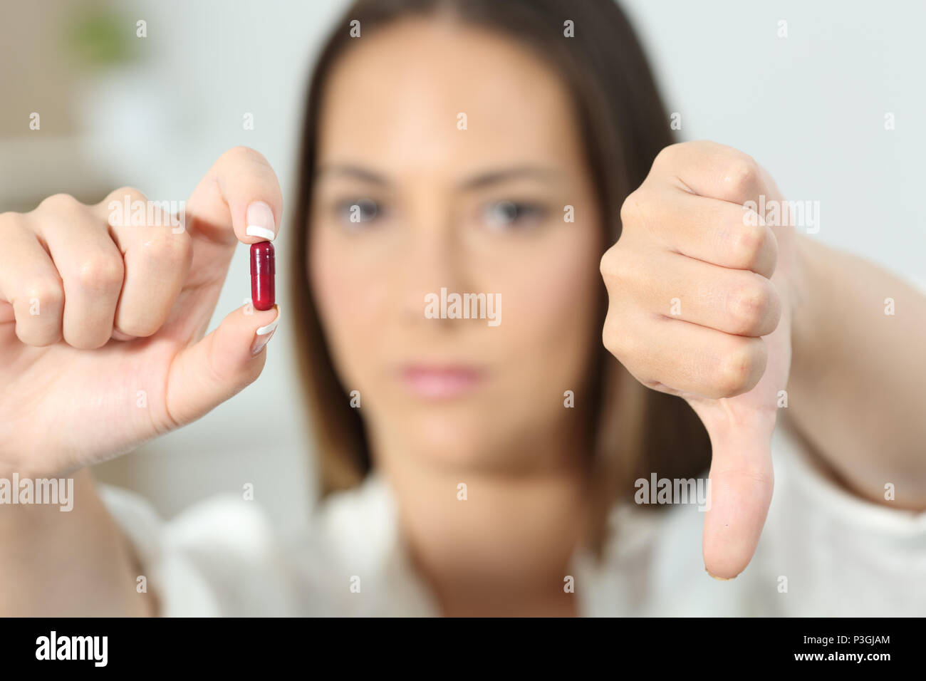 Close up di un arrabbiato donna mano che mostra la pillola con il pollice verso il basso Foto Stock