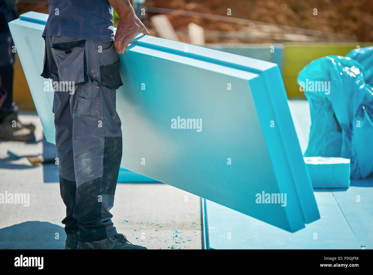 Uomo al lavoro con isolamento termico - costruzione di un riscaldamento a pavimento isolamento, warm house, eco friendly isolamento Foto Stock