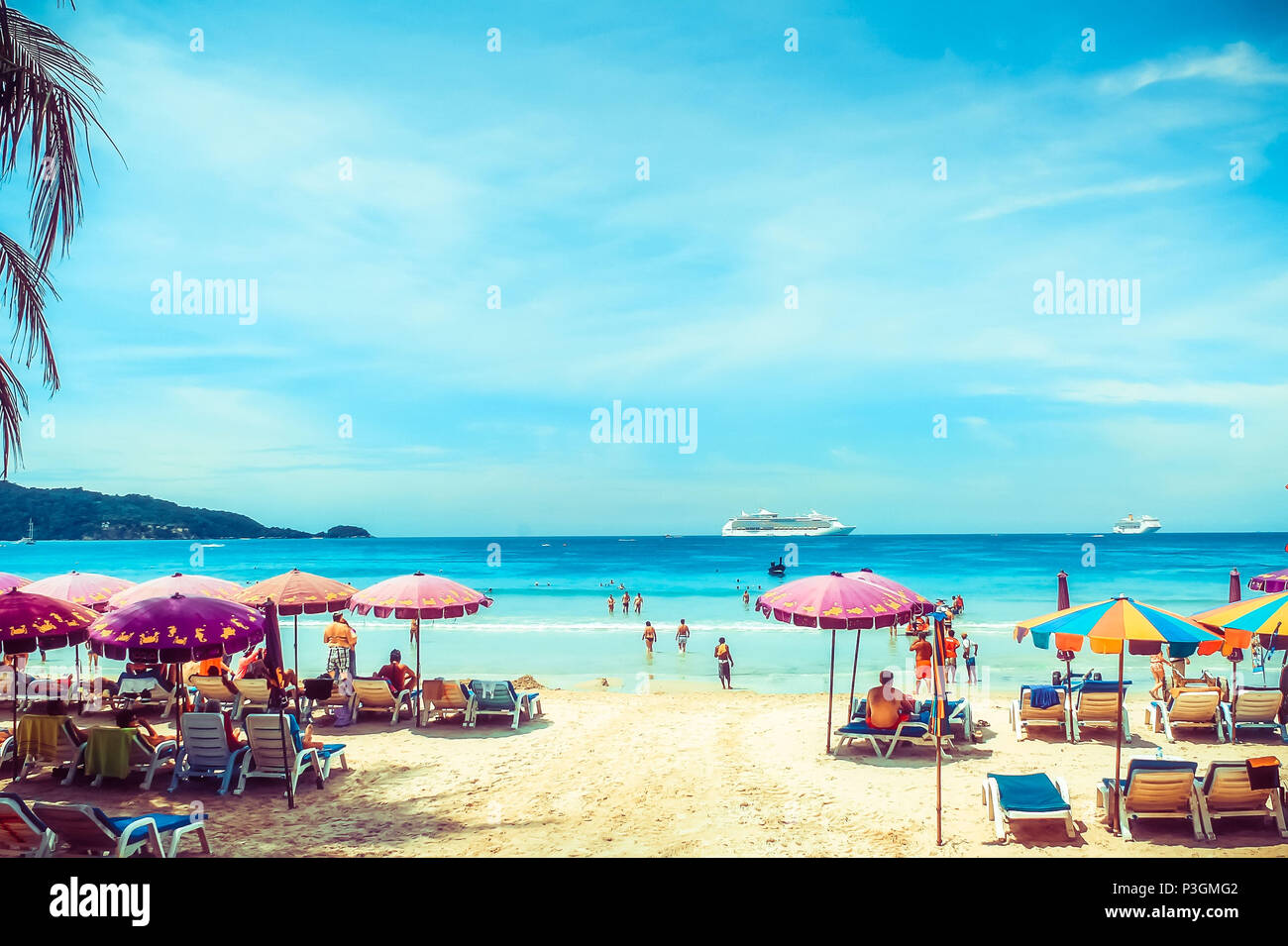 Le persone sono a prendere il sole sulla spiaggia. Molte colorate di ombrelloni e sedie a sdraio sulla spiaggia in una soleggiata giornata estiva. Estate con sfondo colorato ombrelloni da spiaggia Foto Stock