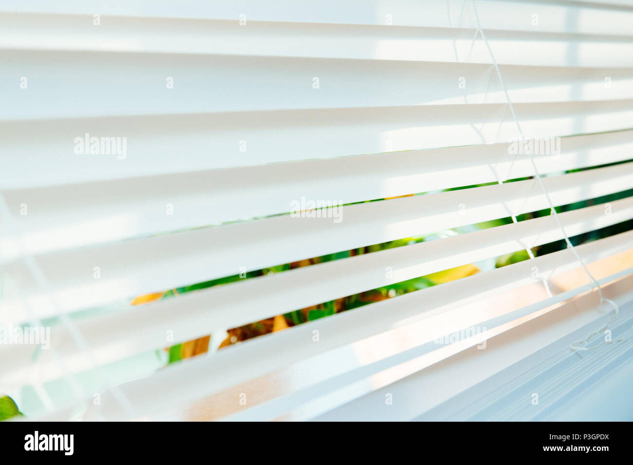 La luce solare filtrata attraverso le persiane con cotone bianco tende. Foto Stock