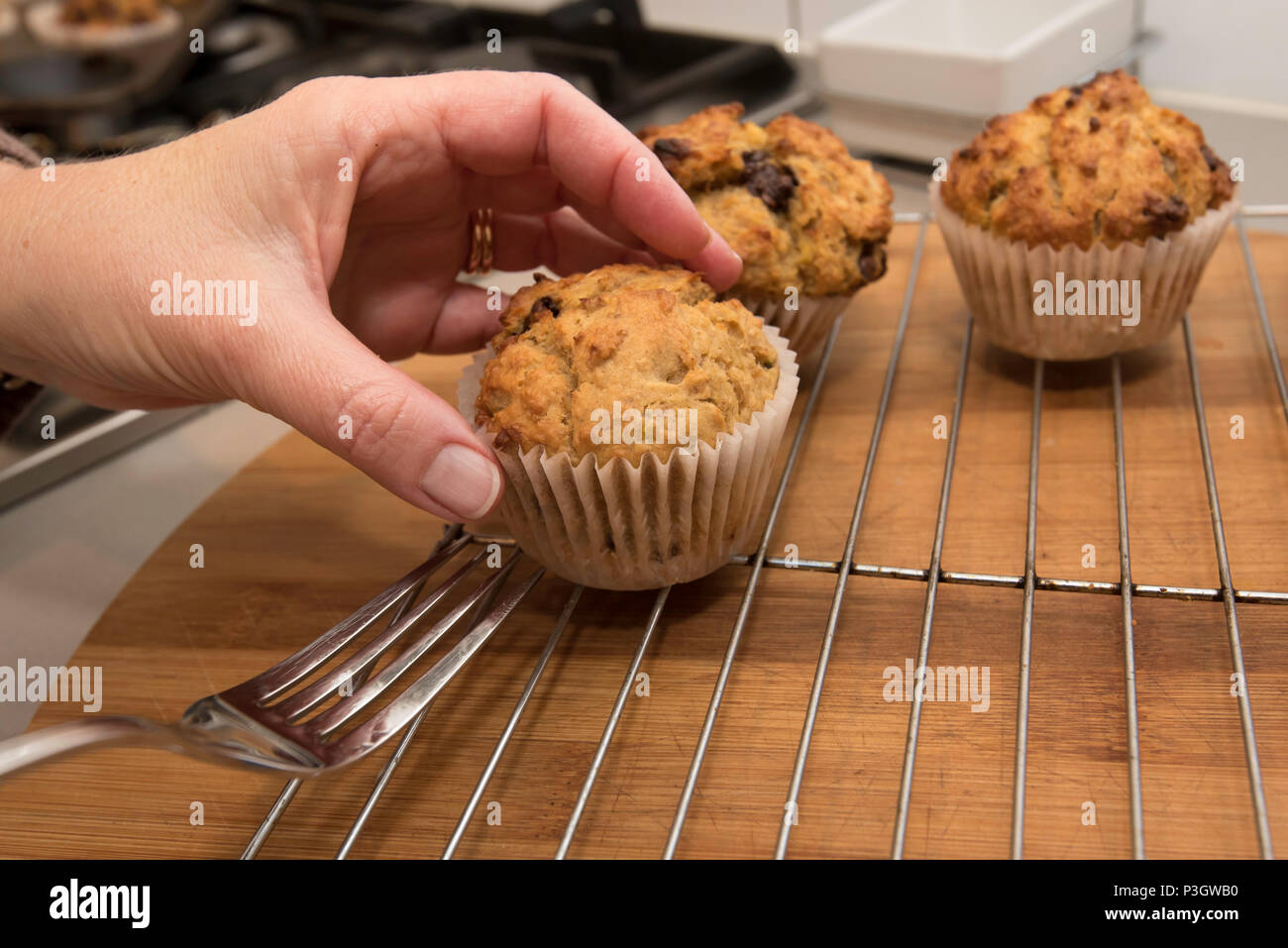 Home cotta golden choc chip, banana e cereali e muffin preparati in una cucina a Sydney in Australia e raffreddare su una griglia per dolci Foto Stock