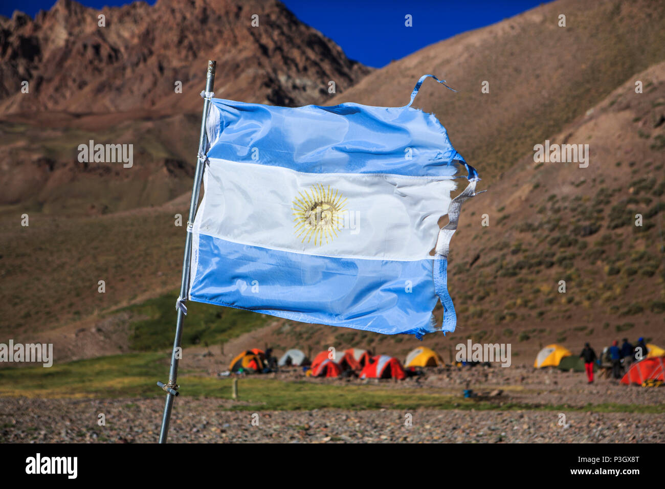 Bandiera argentina sventolando nella parte anteriore del campeggio sull approccio escursione di Aconcagua a Mendoza, Argentina Foto Stock
