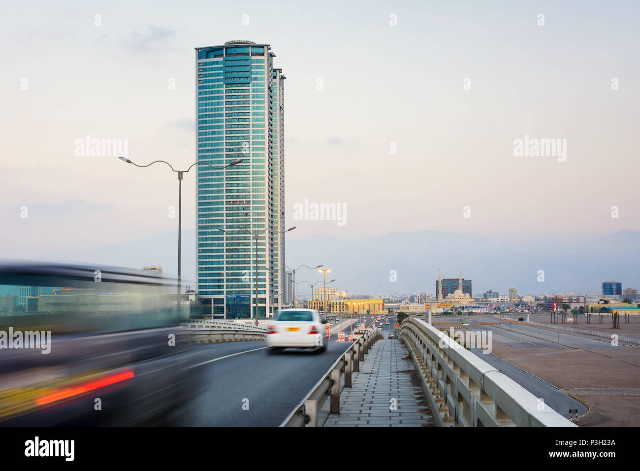 Ras Al Khaimah scena cittadina con vista Torre e auto passando il ponte Foto Stock