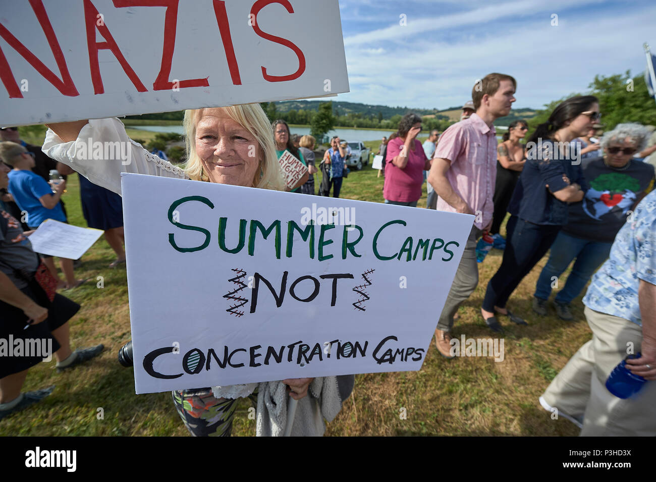 Sheridan, Oregon, Stati Uniti d'America. 18 Giugno, 2018. Persone di manifestare contro la Trump politica amministrativa di separare i bambini dai loro genitori a US-Messico contorno durante una veglia al di fuori di un ufficio federale un centro di detenzione a Sheridan, Oregon, Stati Uniti d'America. Credito: Paul Jeffrey/Alamy Live News Foto Stock