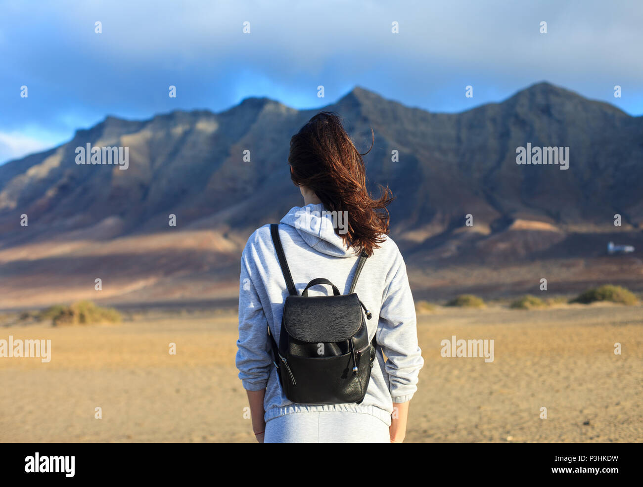 Vista posteriore del viaggiatore donna godendo di splendide montagne paesaggio. Isole Canarie, Spagna. Il concetto di turismo Foto Stock