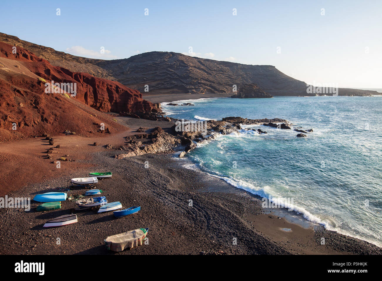 Esclusiva spiaggia di sabbia nera e le barche da pesca a El Golfo, Lanzarote, Isole Canarie. Concetto di viaggio Foto Stock