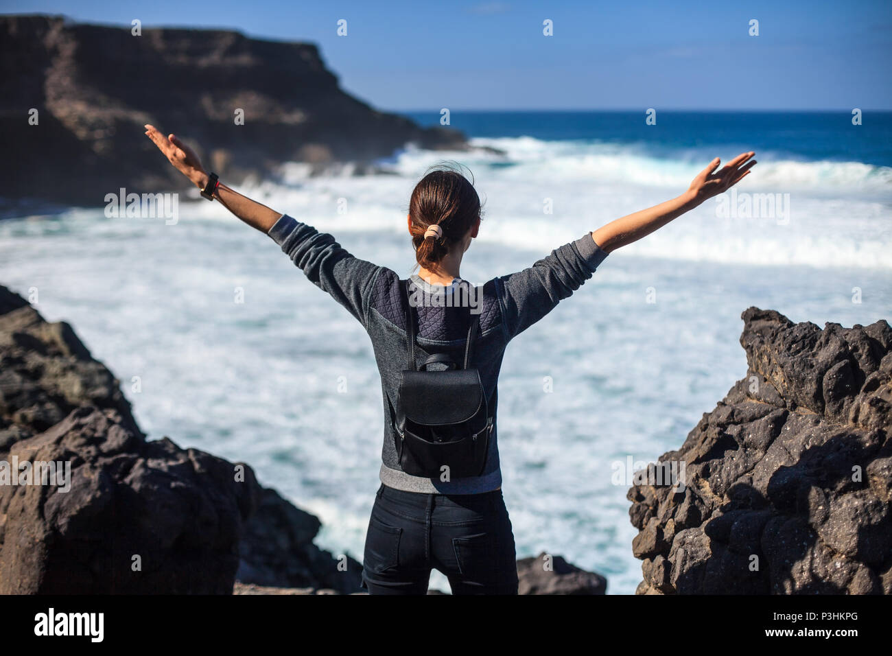 Libertà traveler donna con braccia sollevate godendo oceano. concetto di successo Foto Stock
