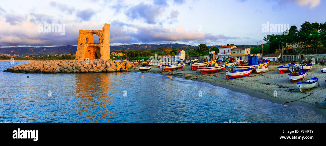 Vecchia Torre ,barche da pesca oltre il tramonto a Briatico,Calabria,l'Italia. Foto Stock
