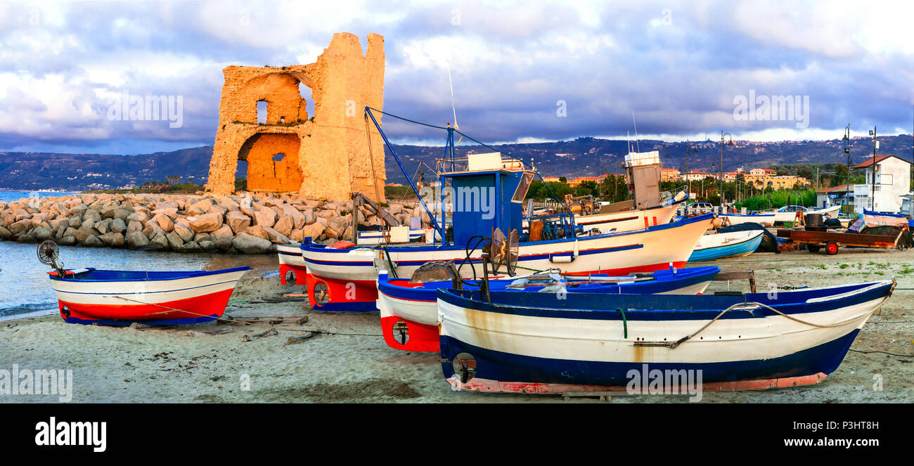 Vecchia Torre oltre il tramonto a Briatico,vista con tradizionali barche da pesca,Calabria,l'Italia. Foto Stock