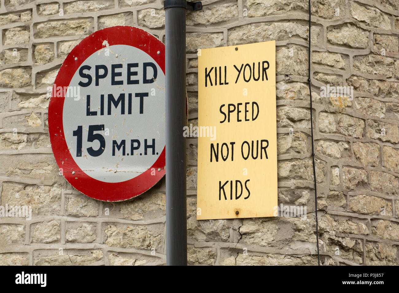 Un segno che richiede i piloti a rallentare a 15mph limite di velocità nella piccola cittadina di mera nel Wiltshire, Inghilterra UK GB. Foto Stock