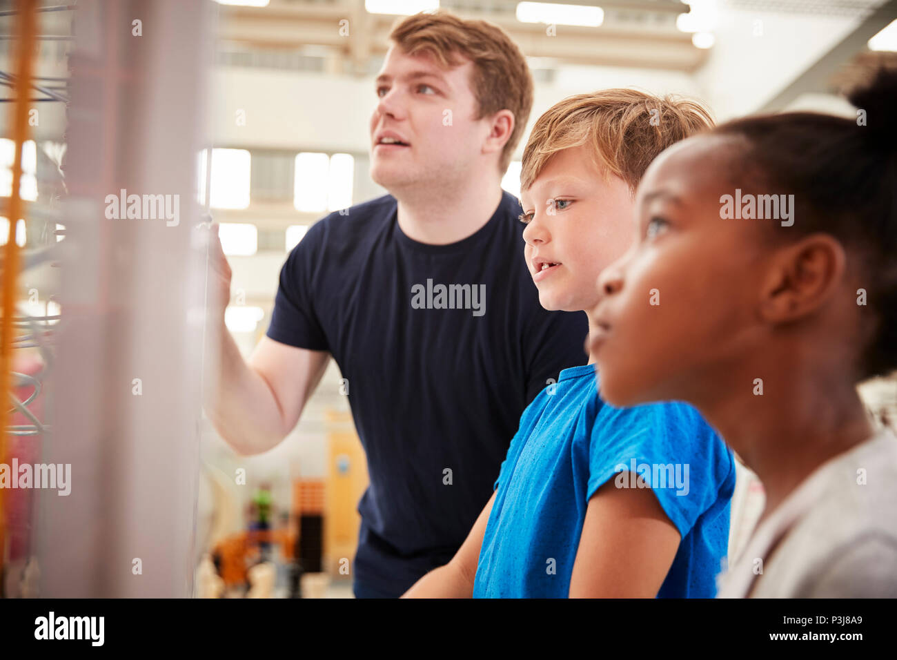 Insegnanti e bambini guardando una scienza presentano, close up Foto Stock