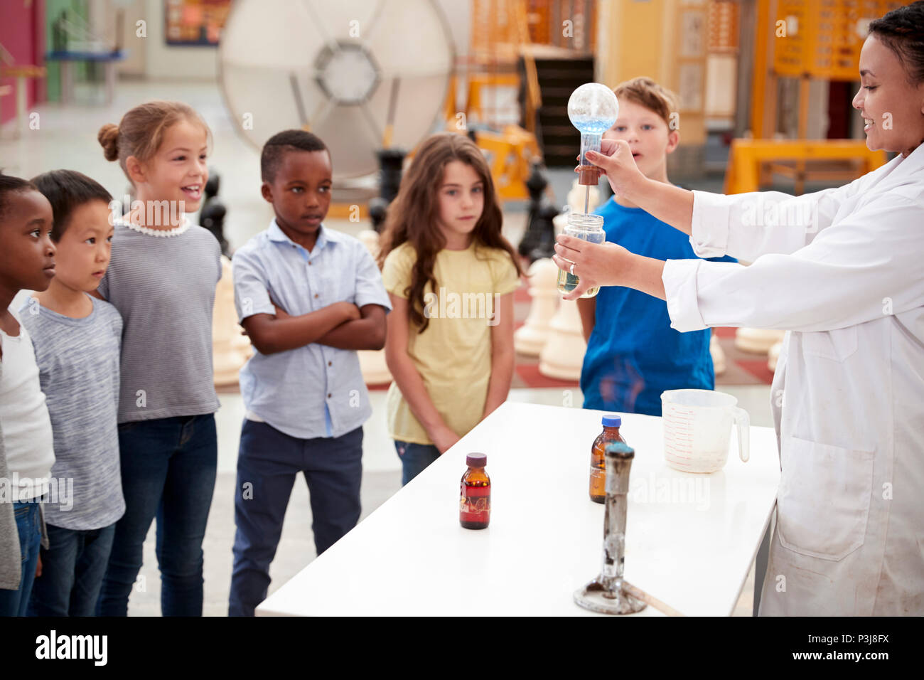 Ai bambini la visione di tecnico di laboratorio effettuare un esperimento scientifico Foto Stock