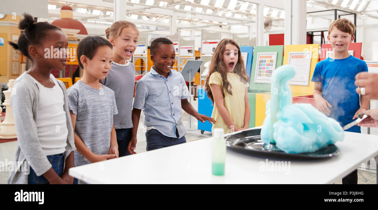 I bambini divertendosi guardando un esperimento in un centro scientifico Foto Stock