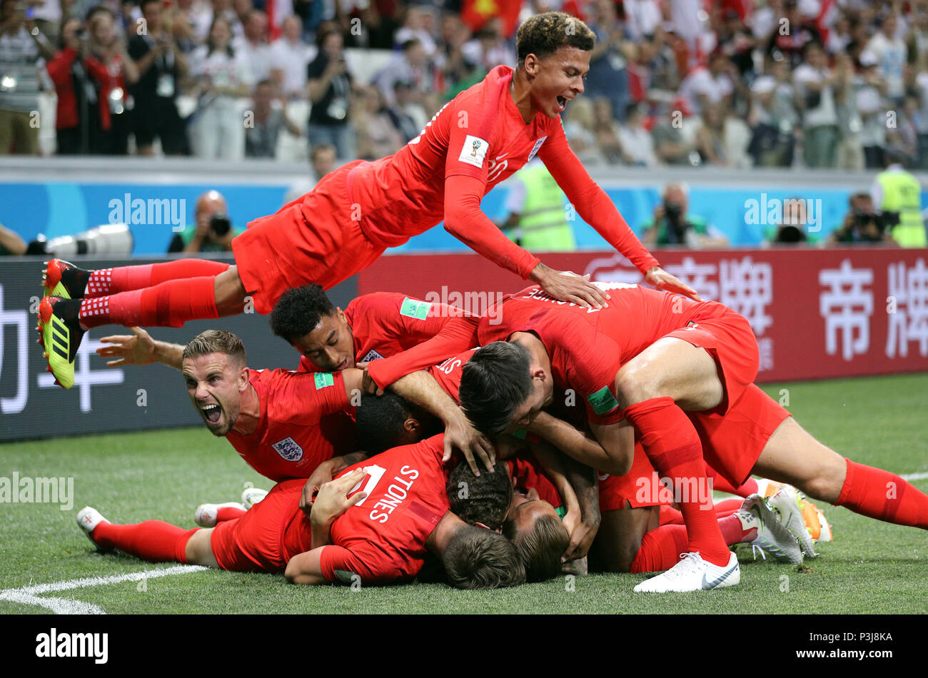 Inghilterra Harry Kane (nascosto) è assaliti da compagni di squadra come punteggi ha il suo lato del primo obiettivo del gioco durante la Coppa del Mondo FIFA Gruppo G corrisponde all'Arena di Volgograd, Volgograd. Foto Stock