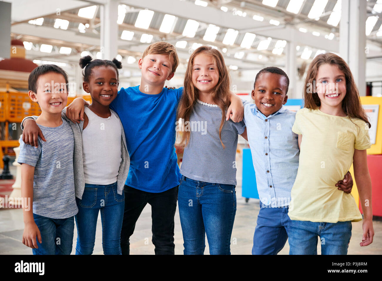 I compagni di scuola che posano per una foto in un centro scientifico Foto Stock