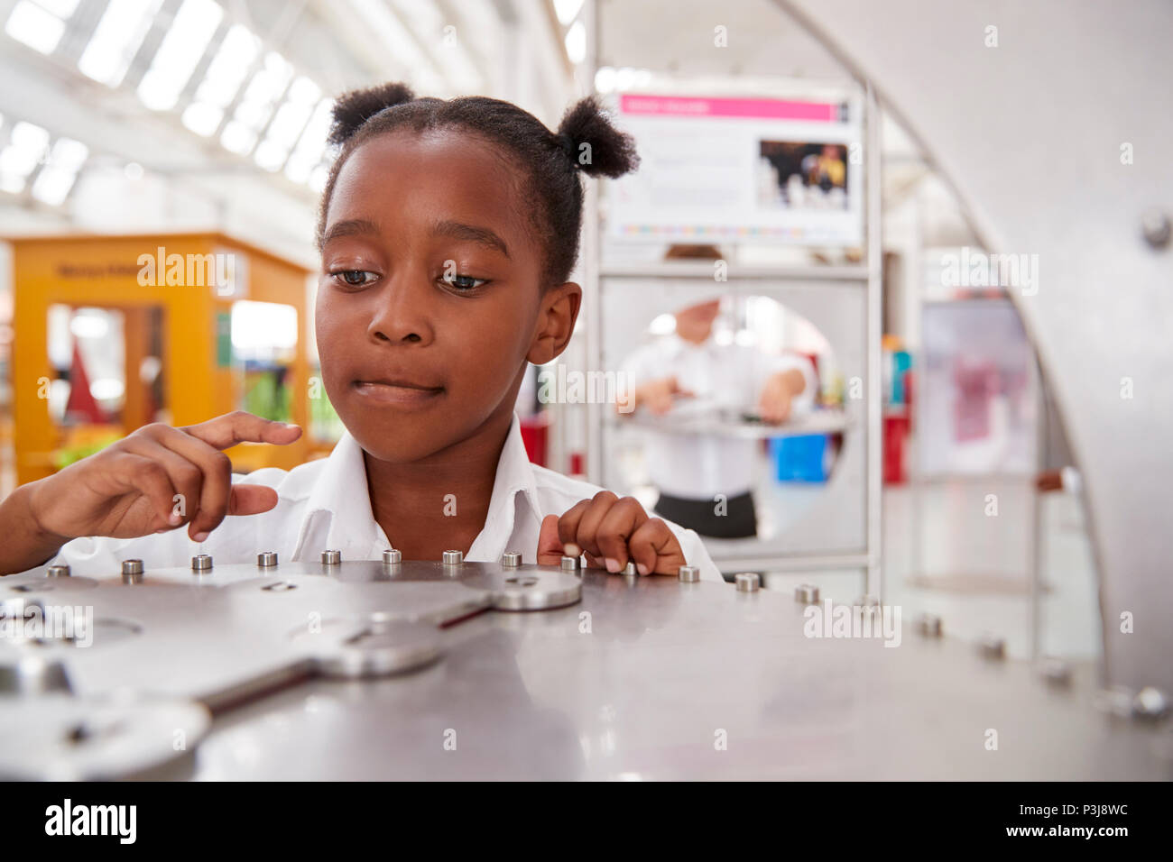 Schoolgirl prendendo parte a una scienza prova in un centro scientifico Foto Stock