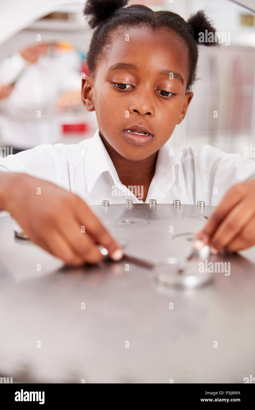Schoolgirl prendendo parte a una scienza prova, verticale Foto Stock
