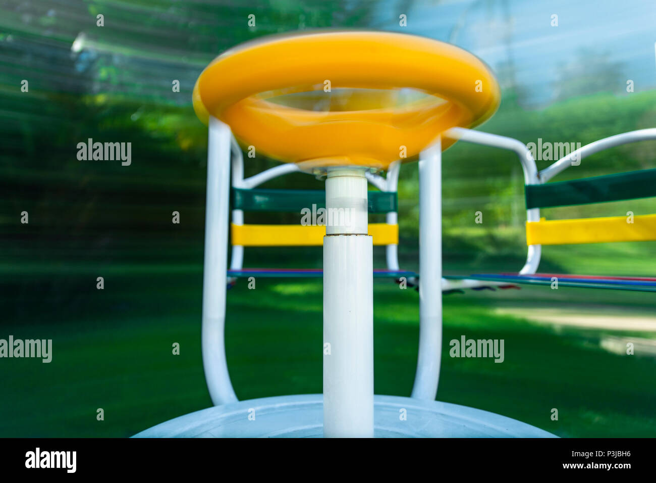 Immagine di un merry-go-round (parco giochi attrezzato) prese in movimento. Una lunga esposizione per mostrare come si gira e movimento. Foto Stock