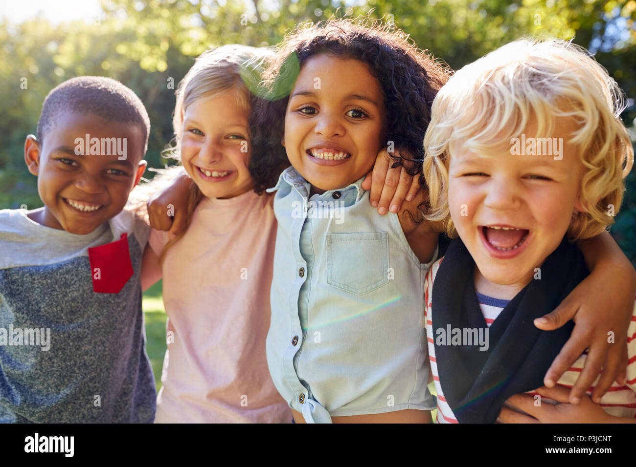 Quattro bambini appendere fuori insieme in giardino Foto Stock