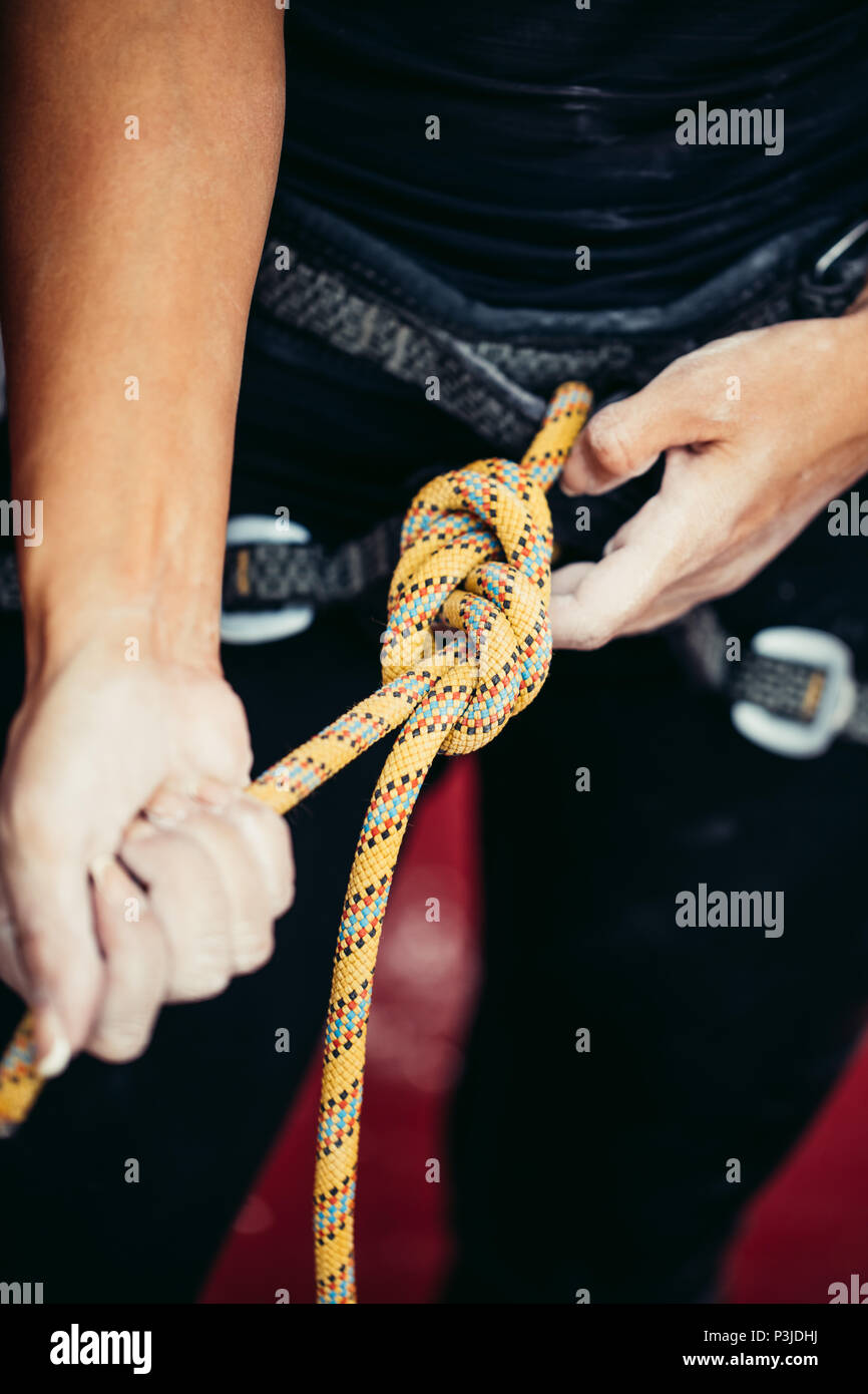 Scalatore di indossare l'imbracatura di sicurezza e fune di sicurezza in, close-up immagine Foto Stock