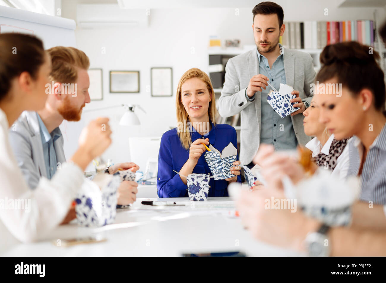 La gente di affari di mangiare in ufficio Foto Stock