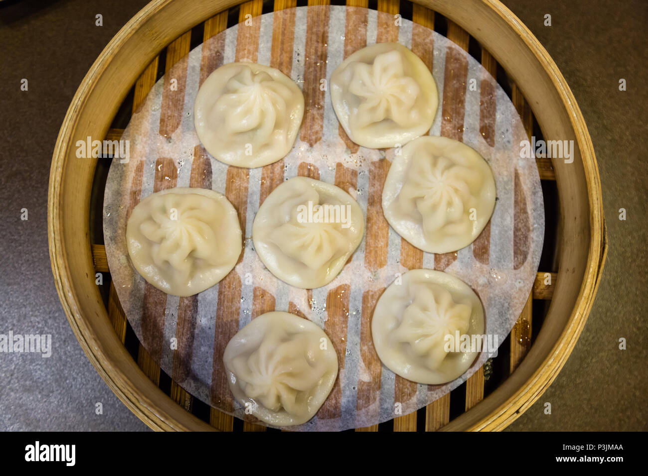 Cinese tradizionale gnocchi vaporizzato in un vaporizzatore di bambù Foto Stock