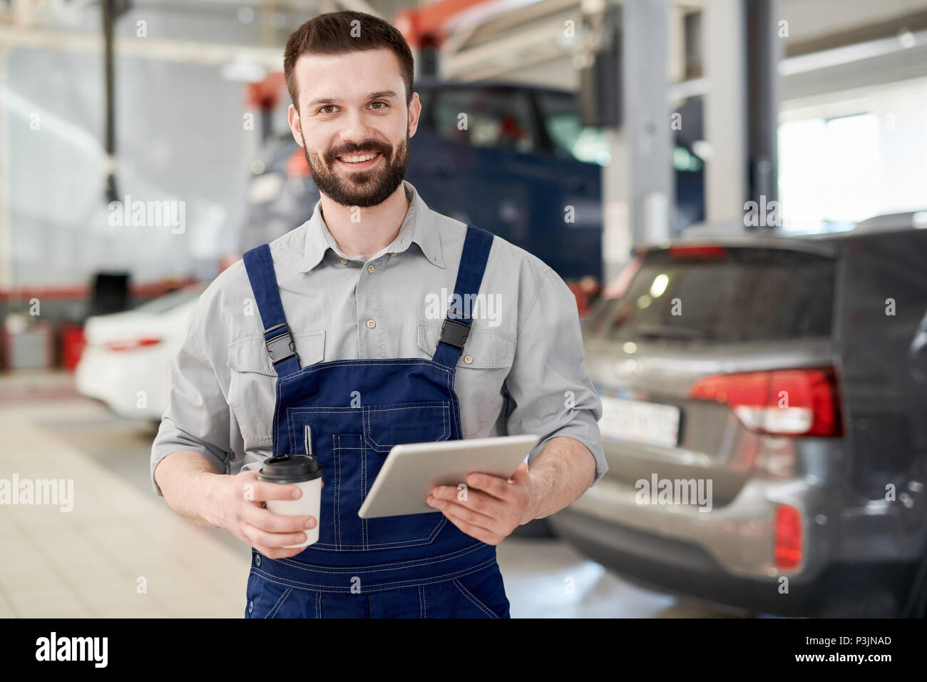 Lavoratore sorridente in auto di servizio Foto Stock