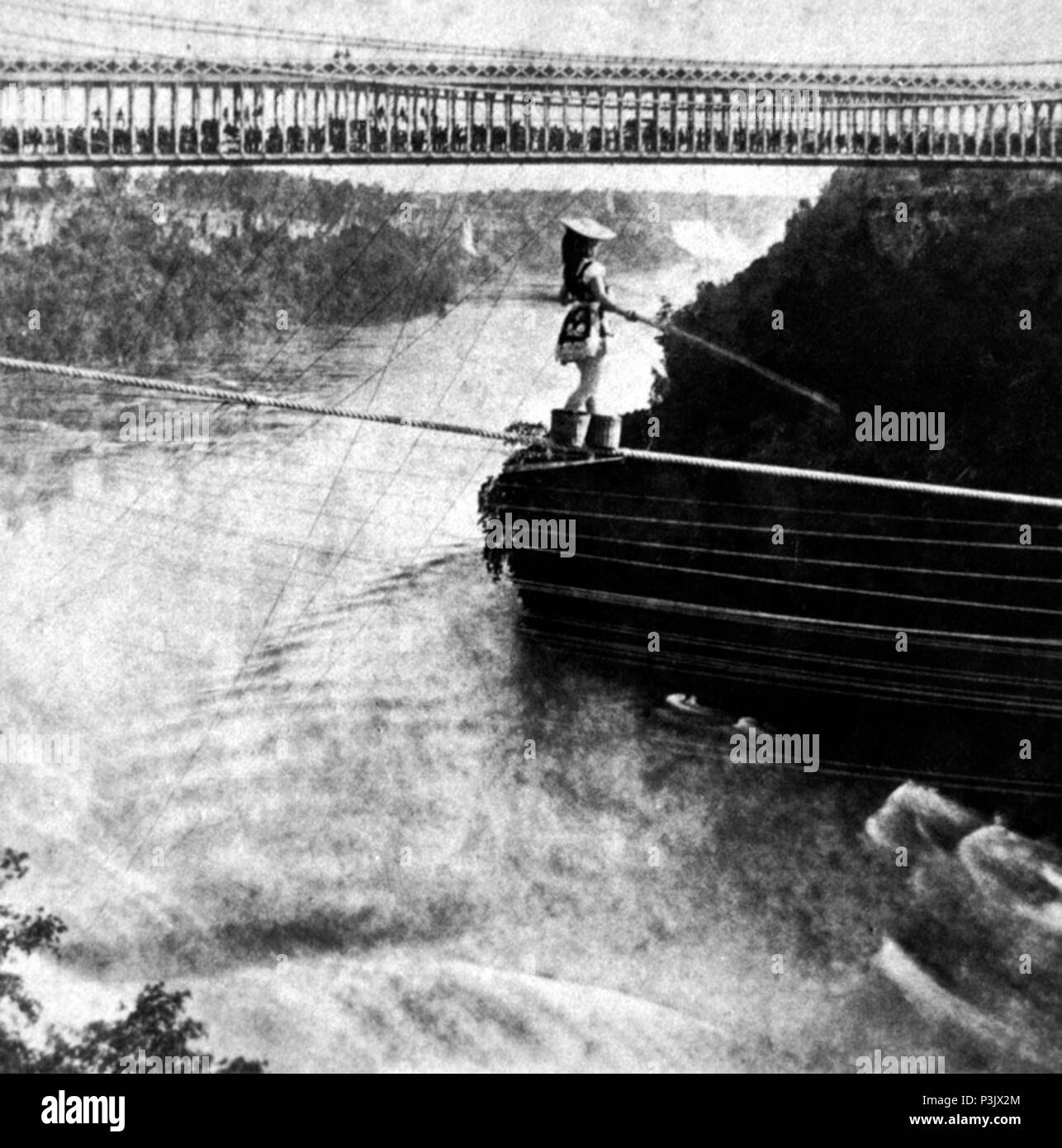 . Inglese: Maria Spelterini è camminare su una fune attraverso il Niagara Gorge, dagli Stati Uniti al lato in Canada con i suoi piedi in cesti di pesche. In fondo è il Niagara ponte di sospensione, che è pieno di spettatori. Nel lontano sullo sfondo delle Cascate del Niagara. 8 luglio 1876. George E. Curtis (1830-1910)[2] 3 Maria Spelterini al ponte di sospensione Foto Stock