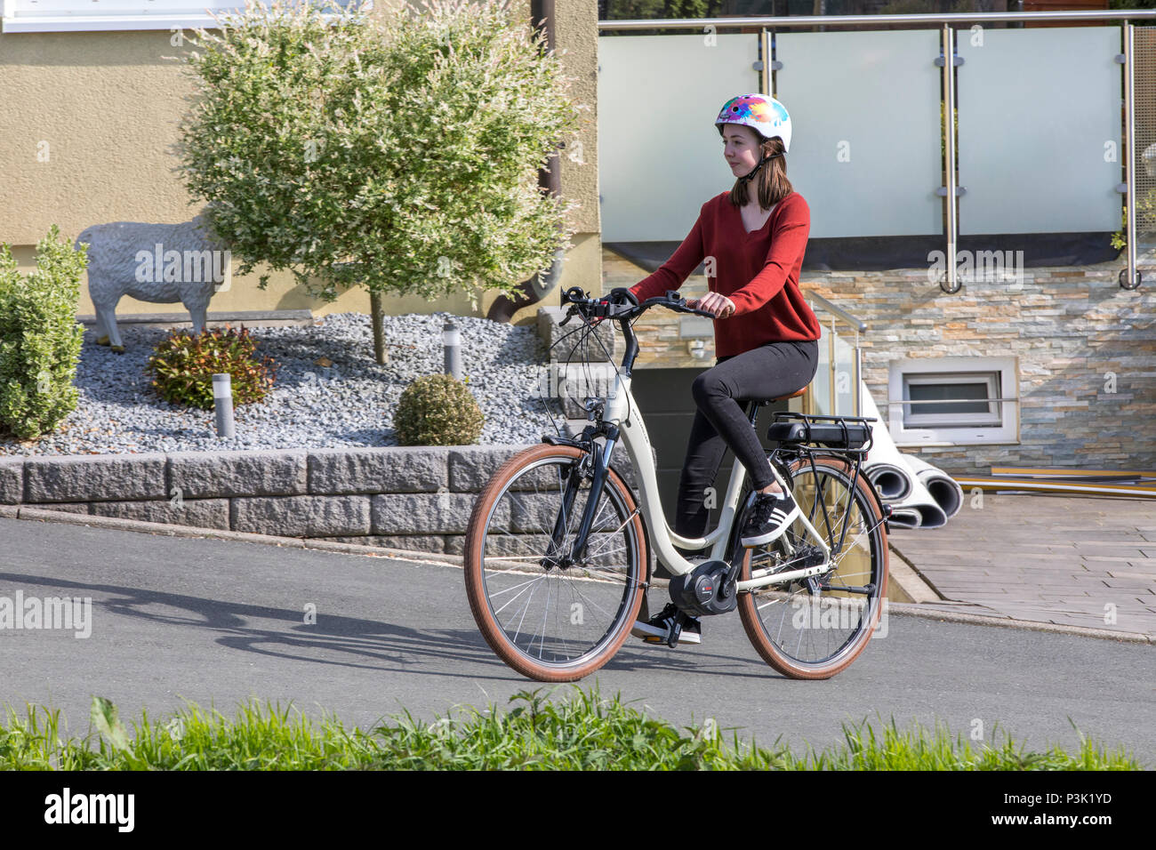 Giovane donna corse un e-bike bicicletta elettrica, motore elettrico guida assistita, Foto Stock