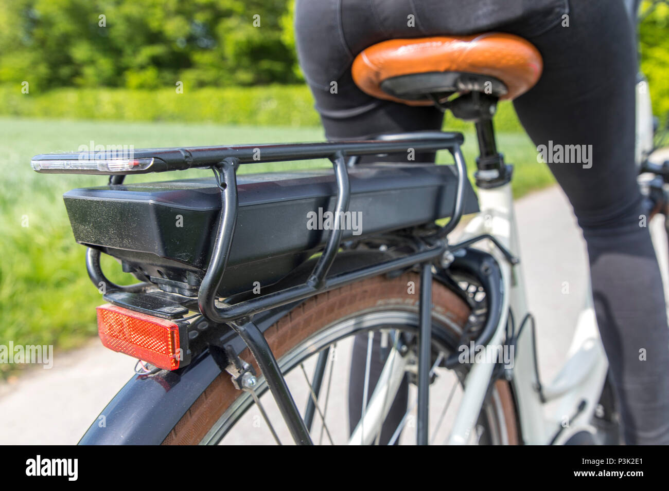 Giovane donna corse un e-bike bicicletta elettrica, motore elettrico guida assistita, batteria ricaricabile, Foto Stock