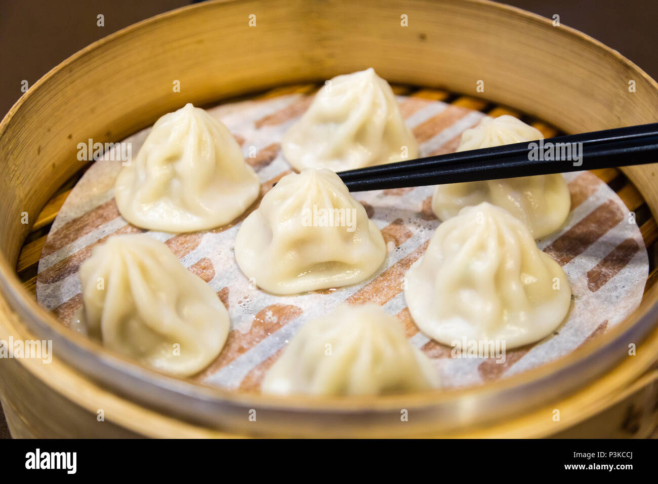 Cinese tradizionale gnocchi vaporizzato in un vaporizzatore di bambù Foto Stock