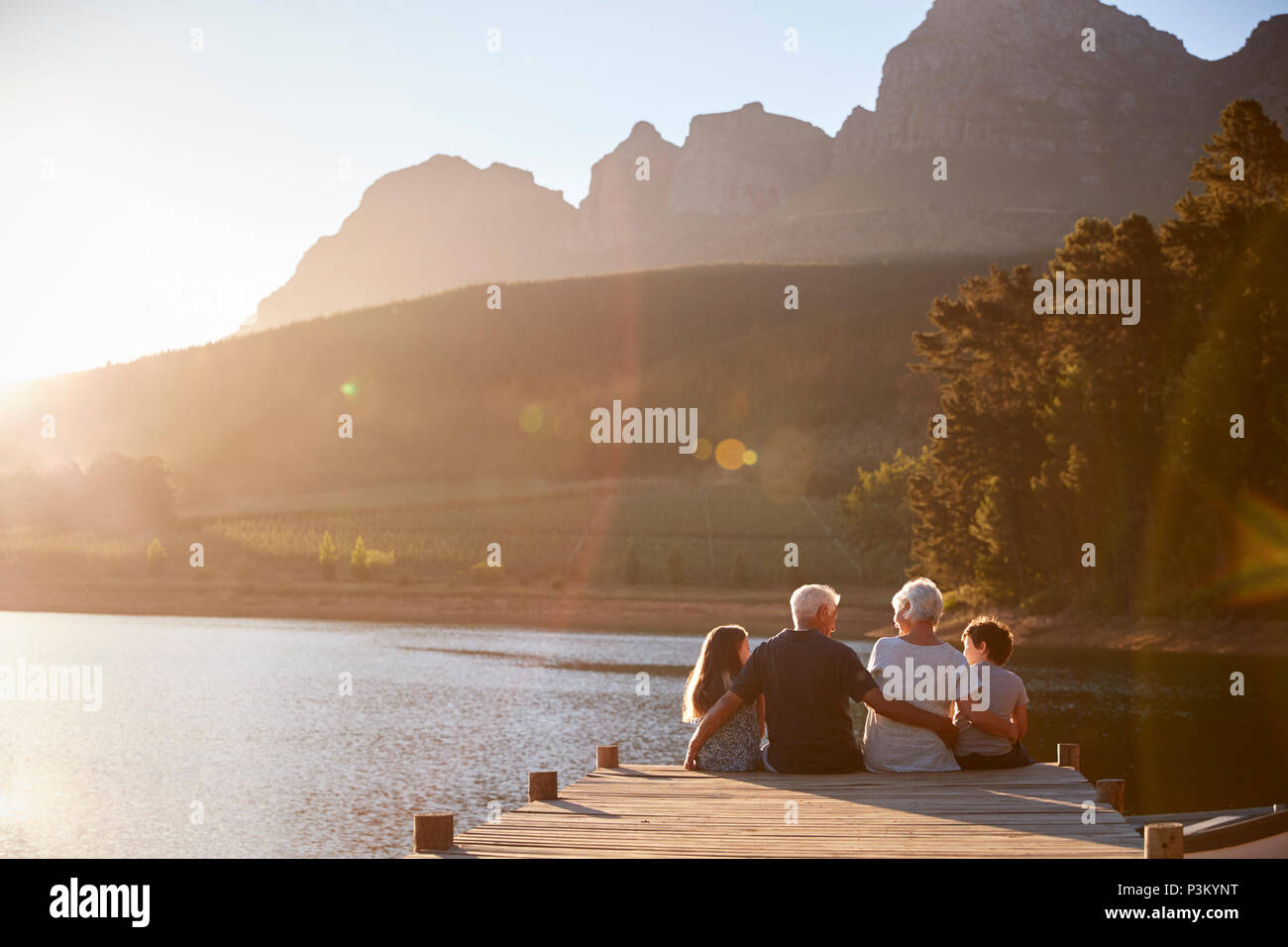 I nipoti con i nonni seduti sul pontile in legno sul Lago di Garda Foto Stock