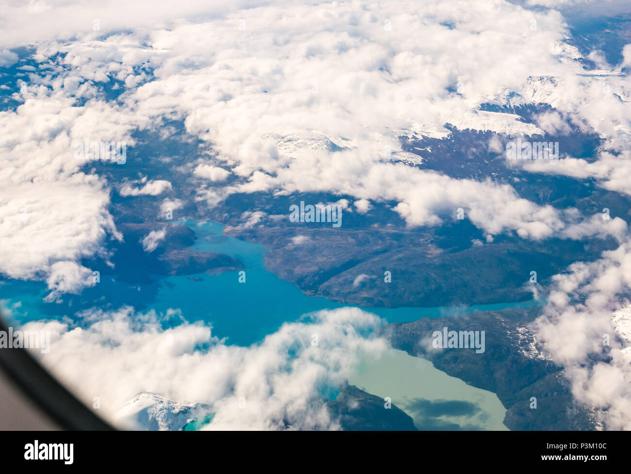 Vista dalla finestra aereo della coperta di neve montagne delle Ande con i laghi di colori differenti, Patagonia meridionale del campo di ghiaccio, Patagonia, Cile Foto Stock