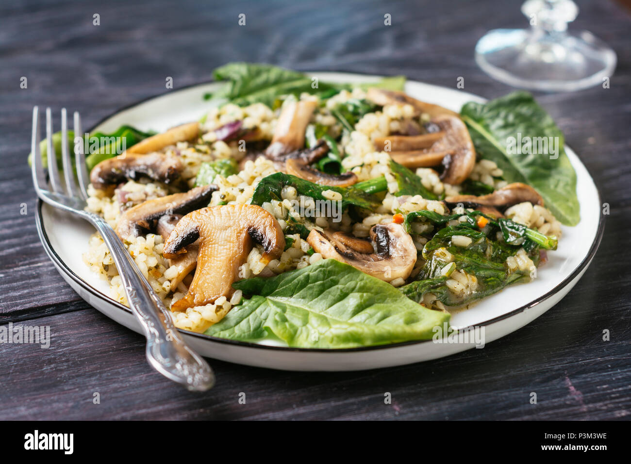 Piastra con un fungo, spinaci Risotto Foto Stock