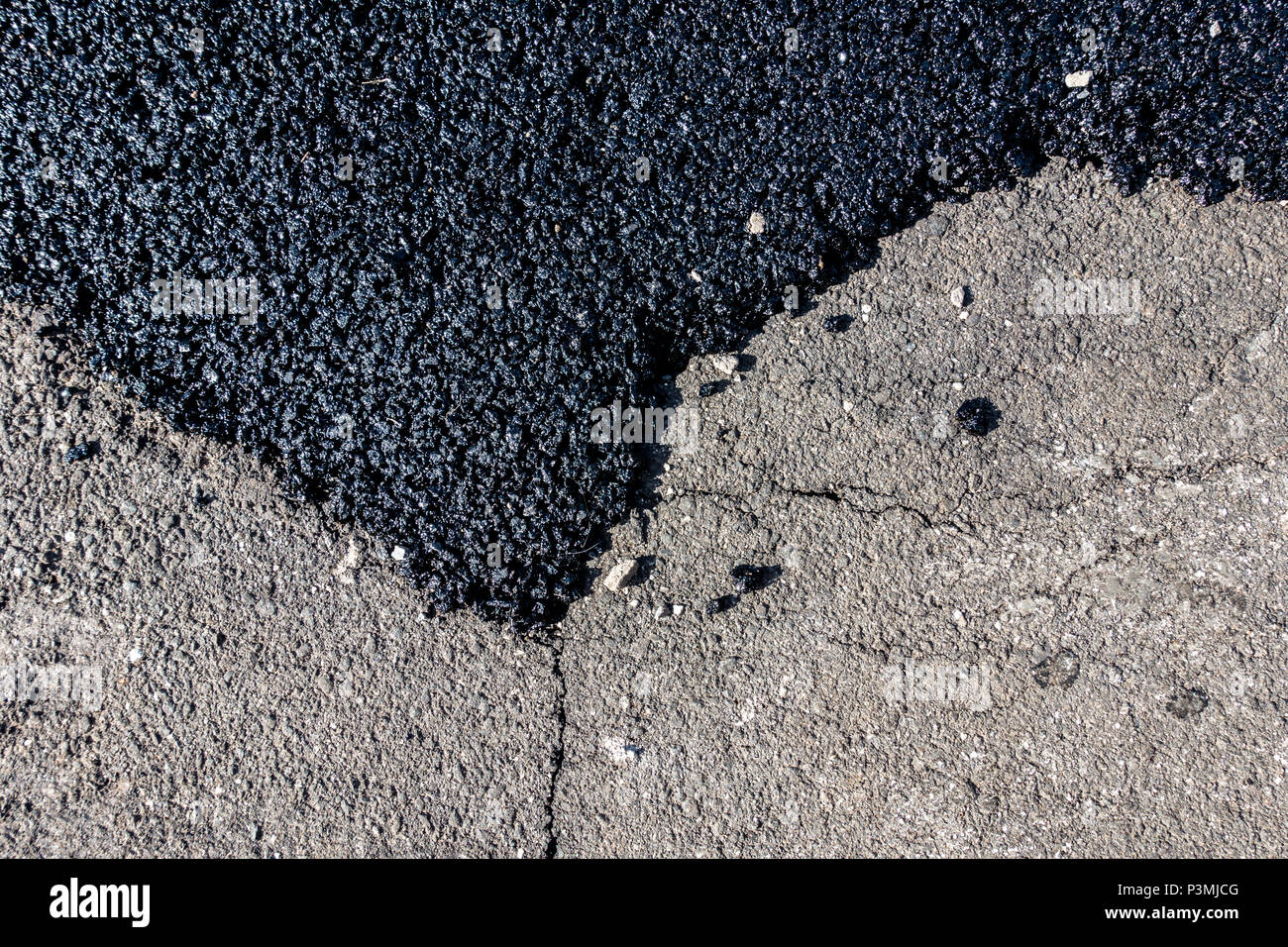 Patch di asfalto sulla strada incrinato. Foto Stock