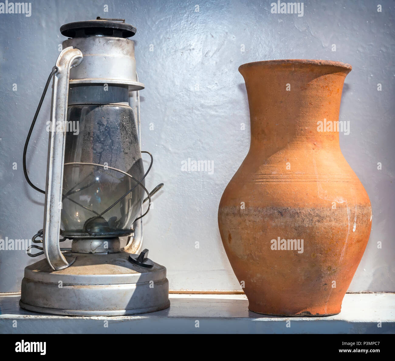Oggetti antichi della vita di tutti i giorni: una lampada di kerosene e una brocca. Foto Stock