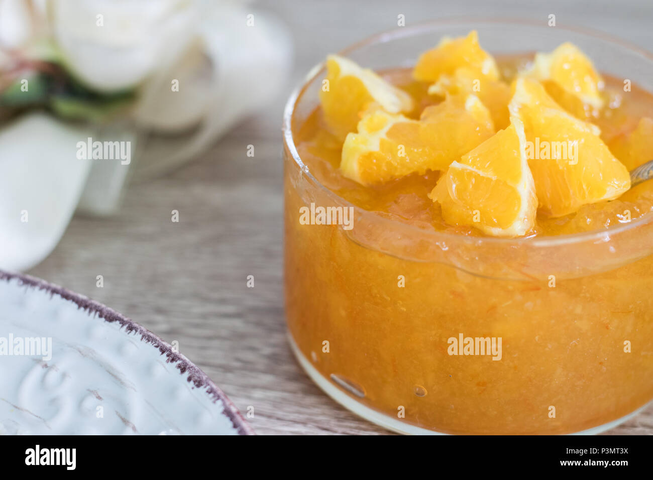 Inceppamento arancione in recipiente di vetro con arancia fresco affettato sulla parte superiore Foto Stock