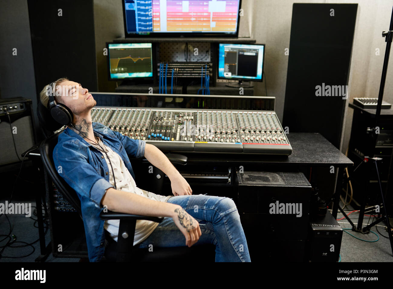 Uomo che ascolta musica in studio Foto Stock