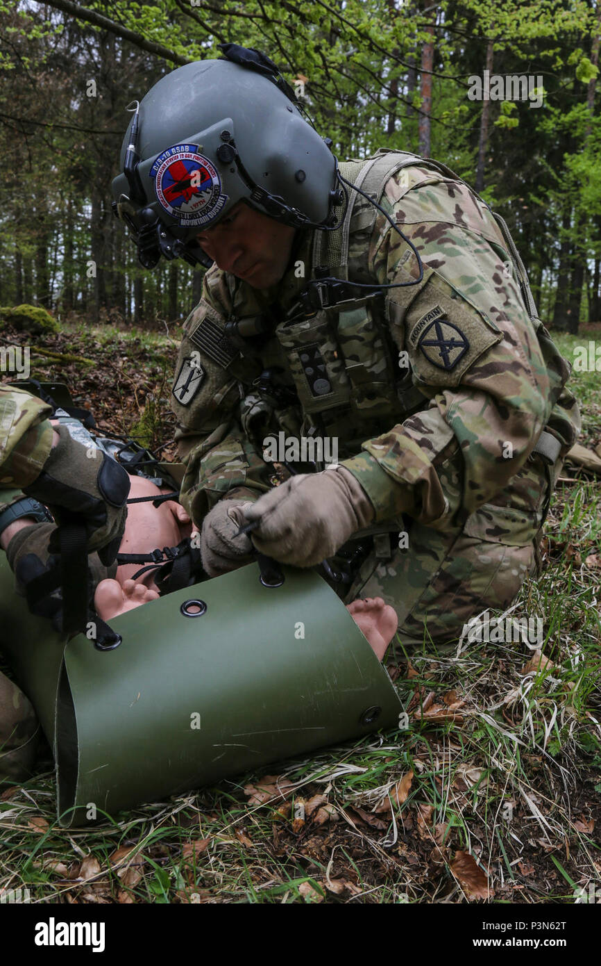 Stati Uniti Il personale dell'esercito Sgt. Jeremy Hall di 3-10 Supporto generale del battaglione di aviazione, decimo combattere la Brigata Aerea assicura una simulazione di incidente per la programmazione oraria cucciolata mentre si conduce una evacuazione medica scenario durante la sciabola di giunzione 17 al Hohenfels Area Formazione, Repubblica federale di Germania il 7 maggio 2017. Saber 17 di giunzione è la U.S. Esercito dell'Europa 2d di cavalleria del reggimento Combat training center esercizio di certificazione, che si svolge presso la multinazionale comune disponibilità centro in Hohenfels, Germania, 25 aprile-maggio 19, 2017. Questo esercizio è progettato per valutare la predisposizione del reggimento di condurre unified operazioni terrestri, con un Foto Stock