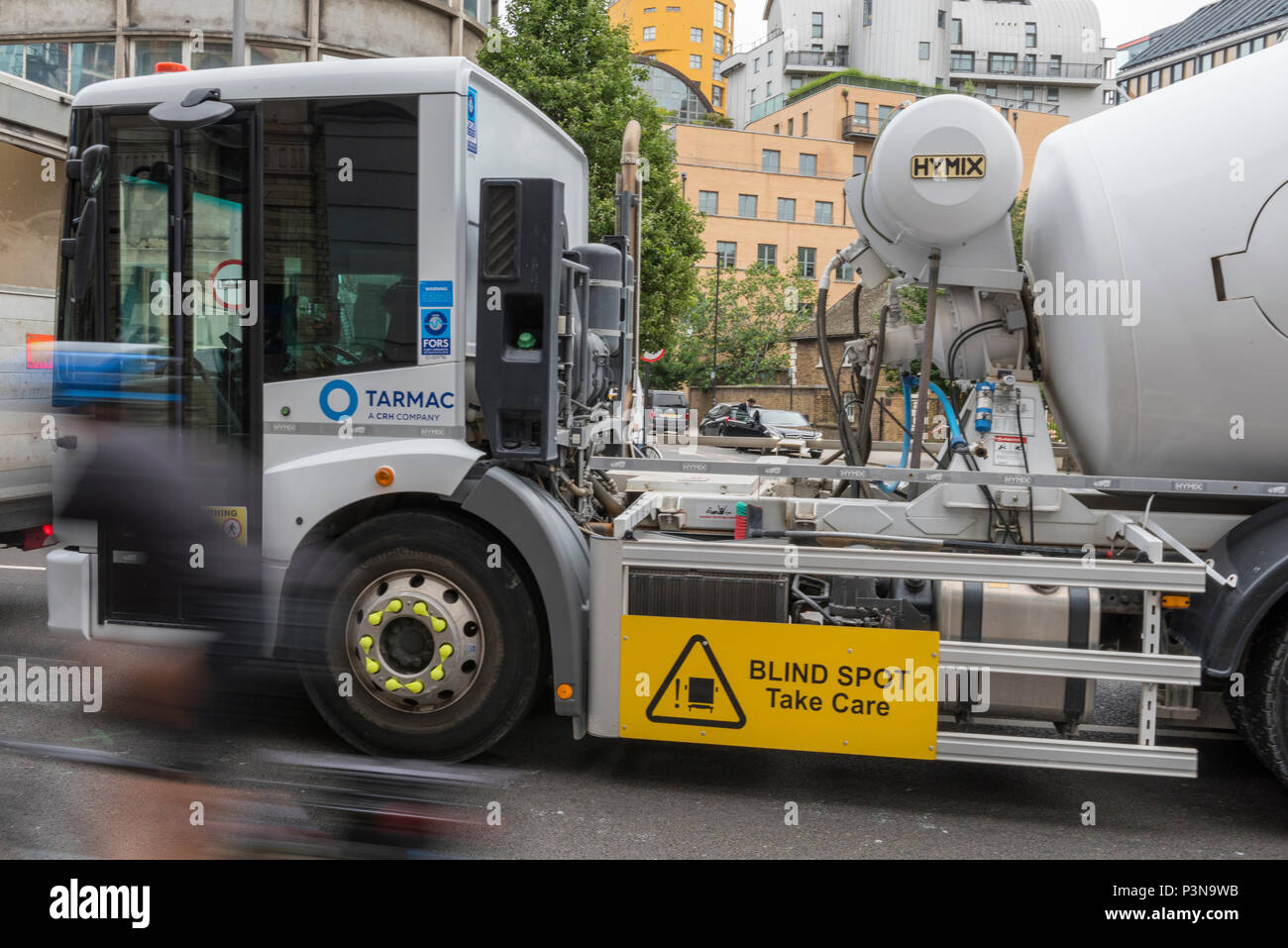 Un ready mix automezzo pesante girando a sinistra su una strada nel centro di Londra. pericolo per ciclisti e soign su di un lato del carrello per avvisare del punto cieco. bici Foto Stock