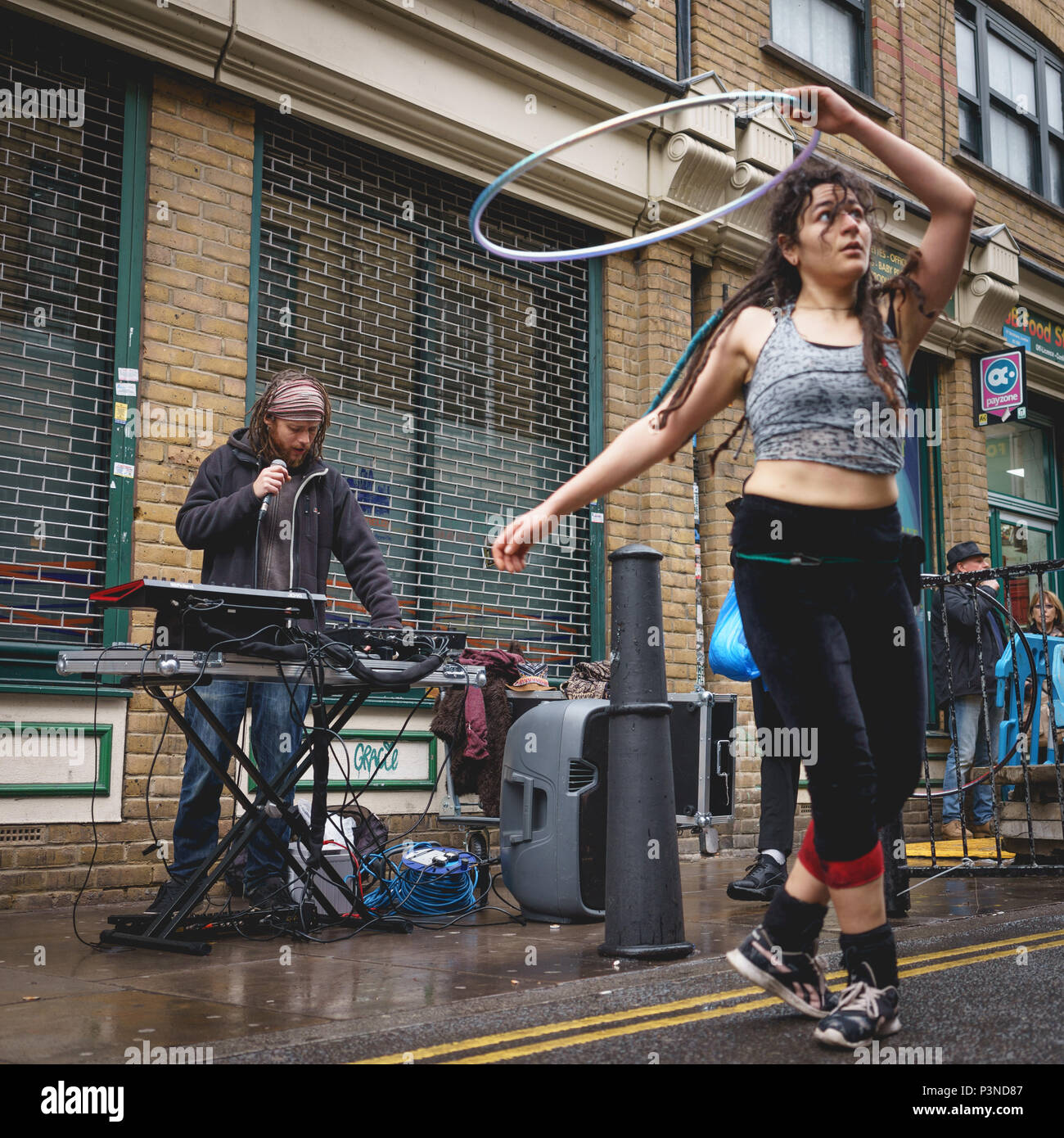 London, Regno Unito - Dicembre 2017. Una strada DJ e un ballerino di eseguire in Brick Lane. Formato quadrato. Foto Stock