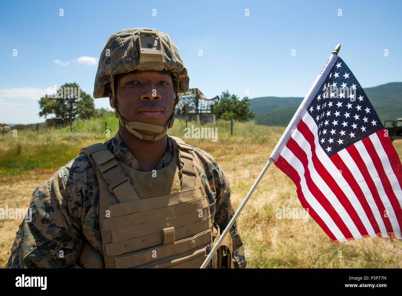Un U.S. Marine con il Mar Nero forza rotazionale detiene una bandiera americana prima di scattare una foto di gruppo con i Royal Marines durante l'esercizio Platinum Lion 16-4 a bordo di Novo Selo Area Formazione, Bulgaria, 13 luglio 2016. Questo multi-nazionale esercizio riunisce otto la NATO e i paesi partner per un live-fire esercizio finalizzato a rafforzare la difesa regionale. (U.S. Marine Corps foto di Cpl. Kelly L. Street, 2D MARDIV COMCAM/rilasciato) Foto Stock